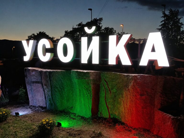 Светещи букви УСОЙКА и изкуствена скала, осветена в трикольор, нощен изглед